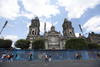 Personas caminan hoy frente a unas vallas metálicas que rodean la Catedral de la Ciudad de México.